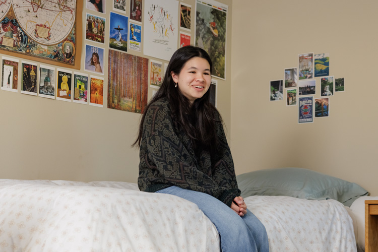 A student sitting on her bed